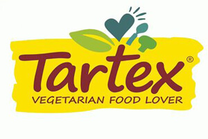 Das Logo zeigt den Schriftzug „Tartex Vegetarian Food Lover“ in Rot und Gelb mit grünen Blättern, Herzen und einem Löffel.