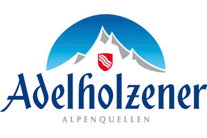 Blau-weißes Logo mit Bergen, einem roten Wappen und dem Schriftzug Adelholzener Alpenquellen in blauer Schrift.