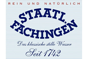 Auf hellblau-weiß gestreiftem Hintergrund steht in dunkelblauer Schrift „STAATL FACHINGEN“, darunter „Das klassische stille Wasser, Seit 1742“.