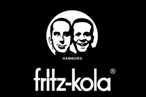 Weißer Schriftzug „fritz-kola“ und „HAMBURG“ vor schwarzem Hintergrund, oberhalb ein rundes Logo mit zwei Köpfen.