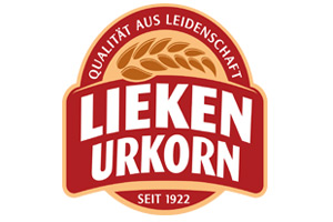 Rotes Logo mit weißem Text: „LIEKEN URKORN“, oben „QUALITÄT AUS LEIDENSCHAFT“, unten „SEIT 1922“, mit goldenen Ähren.