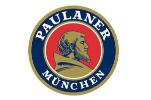 Rundes Logo mit goldenem Rand, rotem Hintergrund, goldener Mönchsfigur und dem Schriftzug „PAULANER MÜNCHEN“ in Weiß.