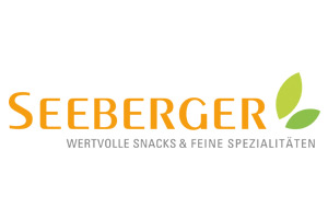 Das Logo der Firma Seeberger zeigt den Schriftzug „Seeberger“ in Orange und darunter „Wertvolle Snacks & Feine Spezialitäten“ in Grau.