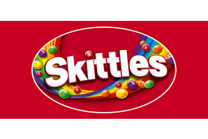 Das Bild zeigt das Skittles-Logo in weißer Schrift auf rotem Hintergrund mit bunten kleinen Kugeln und farbigen Bändern.