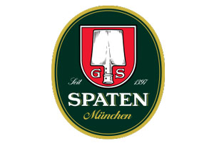 Rotes Wappen mit aufrechter Spitzschaufel, darüber „G S“, umrahmt von grünem Oval mit Schriftzug „Spaten München Seit 1397“.
