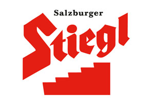 Das rote Logo der Marke Stiegl zeigt den Schriftzug „Salzburger Stiegl“ mit einer stilisierten roten Treppe darunter.