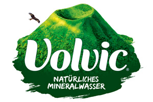 Grüner Vulkan mit einem fliegenden Vogel daneben, darunter der weiße Schriftzug „Volvic Natürliches Mineralwasser“.