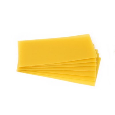 Mehrere übereinanderliegende, rechteckige Lasagneplatten in Gelb auf weißem Hintergrund.