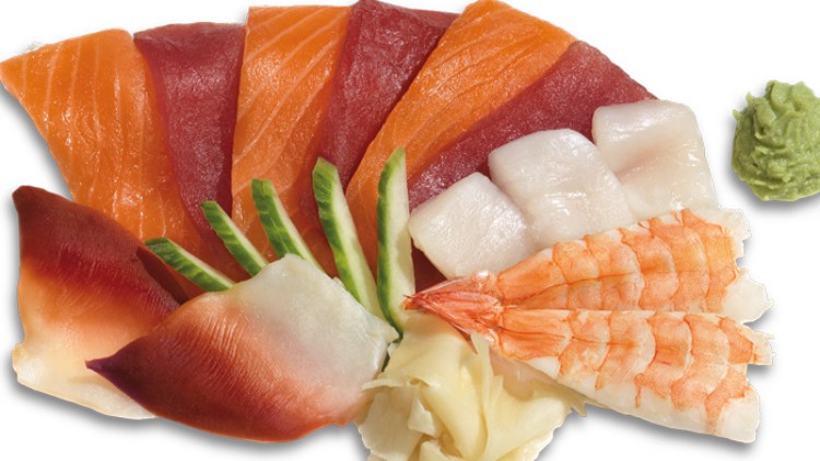 Verschiedene Sorten Sashimi mit Lachs, Thunfisch, Garnelen, Jakobsmuscheln, Ingwer, Wasabi und Gurkenscheiben auf weißem Hintergrund.