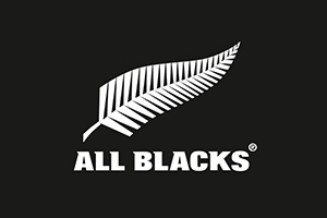 Weiße Farnblatt-Grafik mit dem Text „ALL BLACKS“ in Großbuchstaben auf schwarzem Hintergrund.