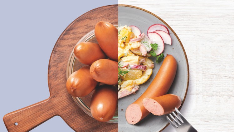 Links liegen mehrere ungekochte Würstchen auf einem hölzernen Brett, rechts ein Teller mit aufgeschnittenem Würstchen und Kartoffelsalat.