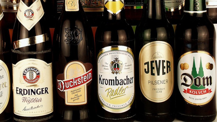 Sechs Bierflaschen mit verschiedenen Etiketten, darunter Erdinger, Duckstein, Krombacher, Jever und Dom Kölsch.