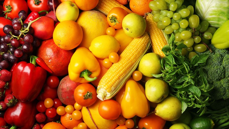 Frisches Obst und Gemüse wie Trauben, Paprika, Tomaten, Mais, Birnen, Basilikum und Brokkoli in diversen Farben und Größen.