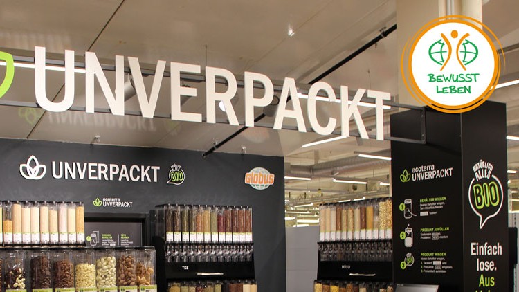 Die GLOBUS Unverpackt-Station zeigt Spender mit Lebensmitteln wie Nudeln, Nüssen und Müsli, beschriftet mit „Alles BIO“.