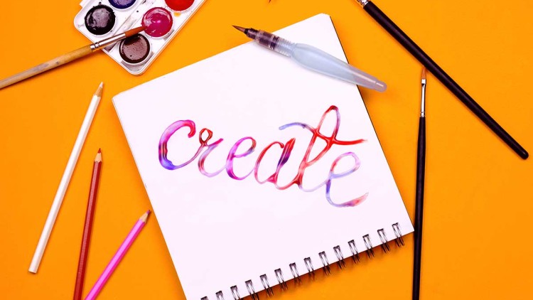Auf einem orangefarbenen Hintergrund liegt ein Block mit dem Schriftzug create in bunter Aquarellschrift, umgeben von Malutensilien.