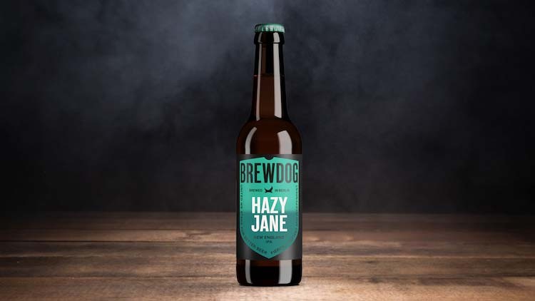 Braune Bierflasche mit türkisfarbenem Etikett und der Aufschrift „BREWDOG HAZY JANE“ auf Holzuntergrund vor dunklem Hintergrund.