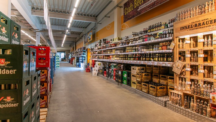 Gang in einem GLOBUS Getränkemarkt mit Bierkisten links und Regalen voller Bierflaschen rechts, darunter Craft Beer Angebote.