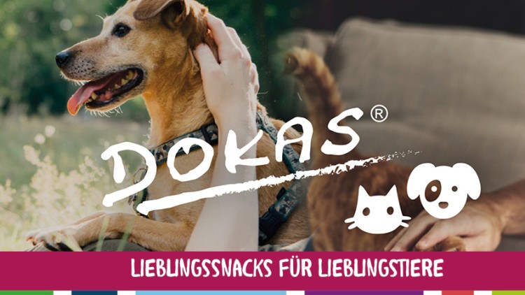 Ein Hund liegt auf einer Wiese, eine Person streichelt ihn, darüber steht „DOKAS“, unten „LIEBLINGSSNACKS FÜR LIEBLINGSTIERE“.