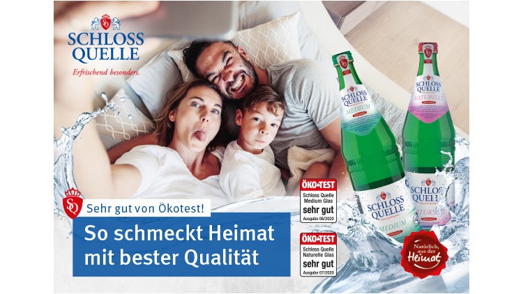 Zwei Schloss-Quelle-Flaschen vor Spritzwasser und Text: So schmeckt Heimat mit bester Qualität, Sehr gut von Ökotest.