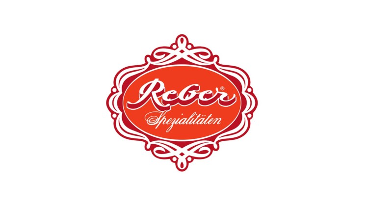 Rotes Logo mit weißem Schriftzug „Reber Spezialitäten“ in geschwungenem Rahmen auf weißem Hintergrund.