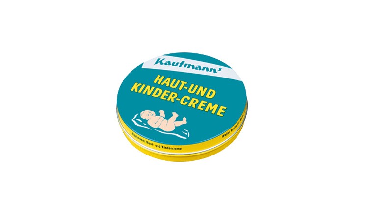 Runde, gelbe Dose mit blauem Deckel, darauf der Text „Kaufmann’s Haut- und Kinder-Creme“ und die Zeichnung eines liegenden Babys.
