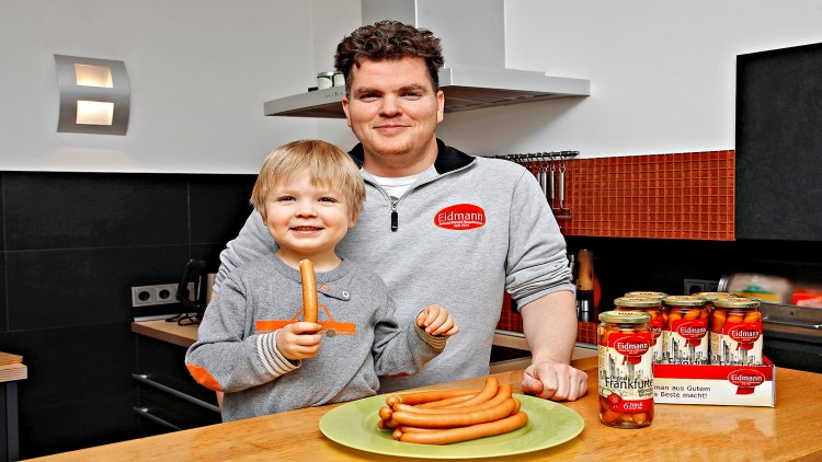Grüne Platte mit mehreren Frankfurter Würstchen neben Gläsern der Marke Eidmann auf einer Küchenarbeitsfläche.