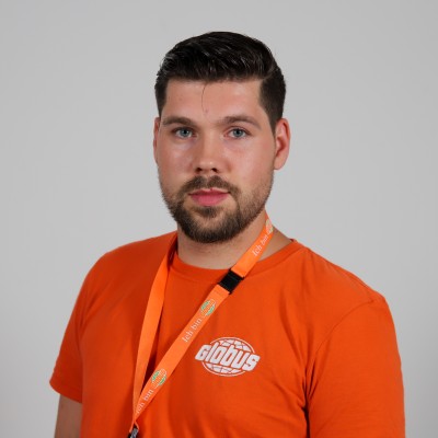 Person in orangefarbenem GLOBUS-T-Shirt mit Logo und passendem Namensband mit Aufschrift „Ich bin GLOBUS“ vor grauem Hintergrund.