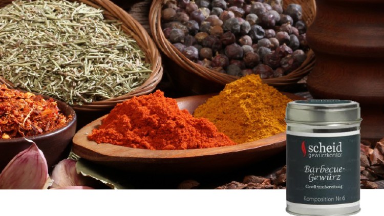 Verschiedene Gewürze in Schalen, darunter Paprika, Kurkuma, Wacholderbeeren und Kräuter, mit einer Gewürzdose von Scheid Gewürzkontor.