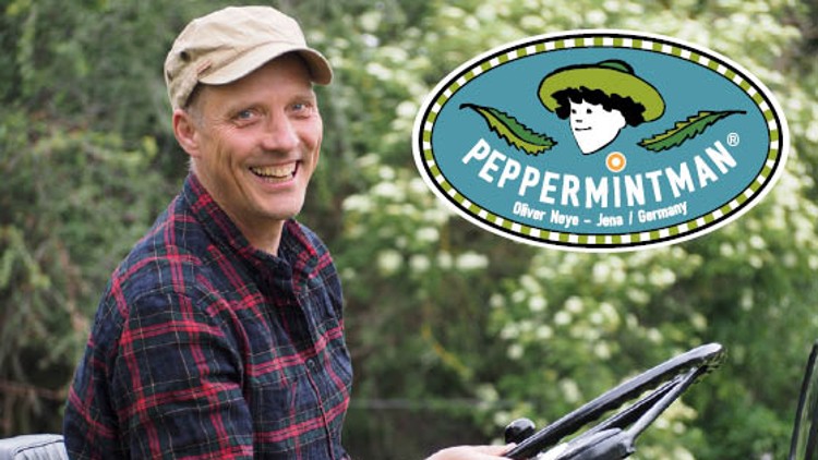 Person in kariertem Hemd sitzt auf einem grünen Fahrzeug, daneben das Logo mit Text „PEPPERMINTMAN – Oliver Neye – Jena – Germany“.