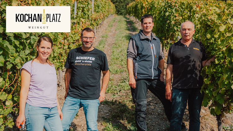 Vier Personen stehen zwischen Weinreben, oben links ist das Logo „KOCHAN UND PLATZ WEINGUT“ auf weißem Hintergrund.