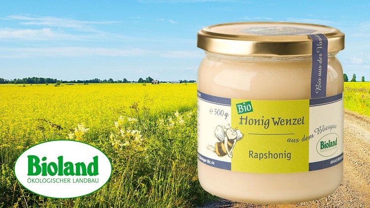 Ein Glas Bio Rapshonig der Marke Honig Wenzel mit Bioland-Siegel, im Hintergrund gelbes Rapsfeld und blauer Himmel.