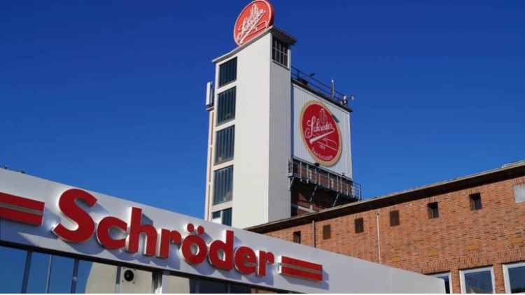 Ein Gebäude mit Schriftzug „Schröder“ und rotem Logo mit Schrift „Schröder seit 1816“ vor blauem Himmel.