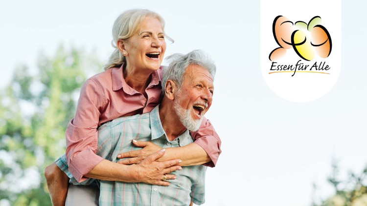 Person mit grauen Haaren trägt eine Person im rosa Hemd huckepack, im Hintergrund Bäume, rechts das Logo „Essen für Alle“.