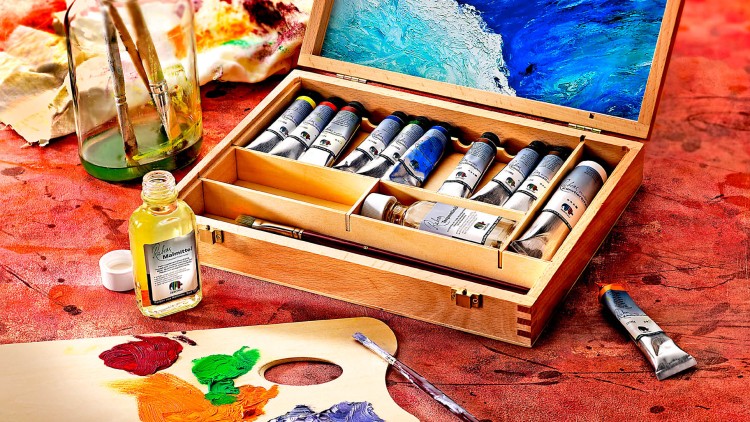 Offene Holzkiste mit Künstlerfarben, Pinsel, Malmittel, Farbpalette mit Farben und Glas mit Pinseln auf rot marmorierter Oberfläche.