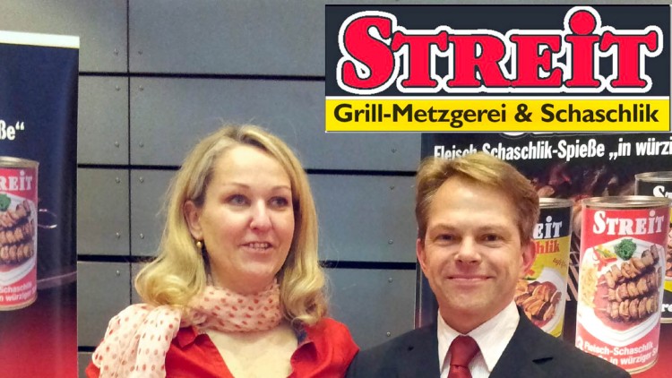 Werbeplakate der Marke STREIT Grill-Metzgerei & Schaschlik mit Bildern von Konservendosen und Fleischspießen im Hintergrund.