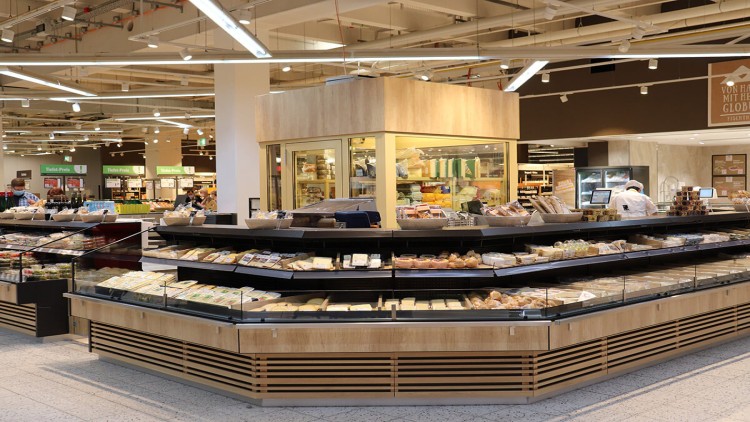 Verkaufsbereich in einem GLOBUS-Markt mit einer Käse- und Backwarentheke, im Hintergrund weitere Einkaufsregale.