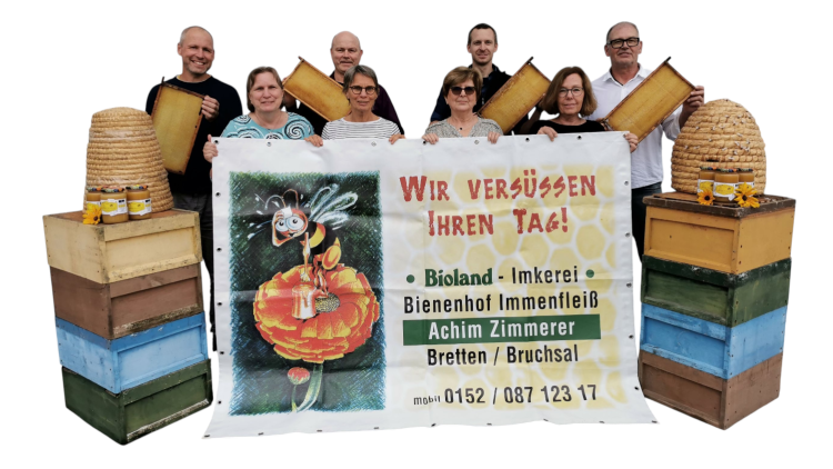 Personen halten Bienenwaben vor einem Banner mit der Aufschrift: „Wir versüßen Ihren Tag! Bioland-Imkerei Bienenhof Immenfleiß“.