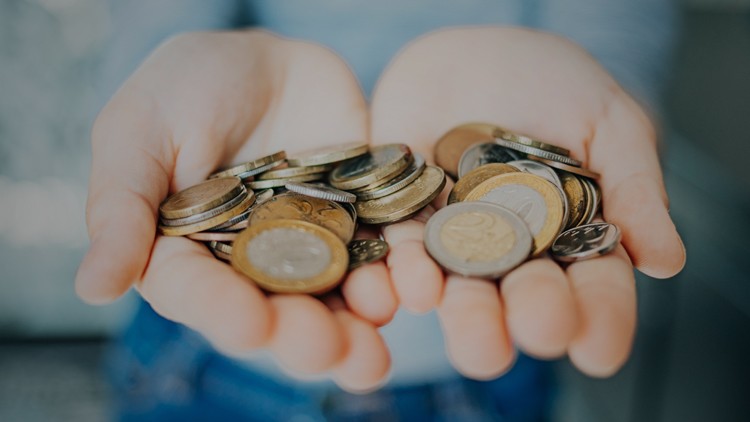 Zwei geöffnete Hände halten mehrere Euro-Münzen in unterschiedlicher Größe und Prägung.